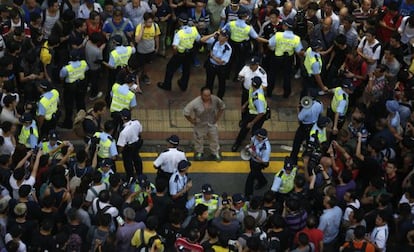 La policía rodea a un hombre herido tras enfrentarse ayer a los manifestantes en el barrio hongkonés de Mong Kok.