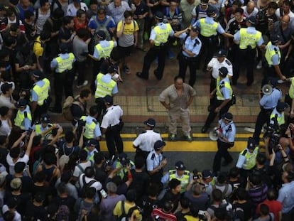 La polic&iacute;a rodea a un hombre herido tras enfrentarse ayer a los manifestantes en el barrio hongkon&eacute;s de Mong Kok. 