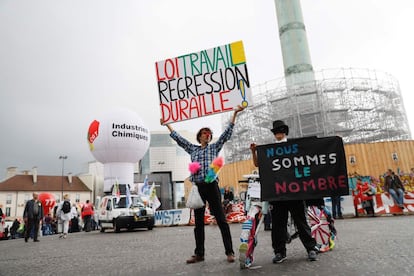 Un manifestante francés alza una pancarta donde se lee: "derecho laboral - dura regresión" al lado de la pancarta de otro manifestante que dice: "Somos números", como parte de la protesta contra la reforma laboral, en París.
