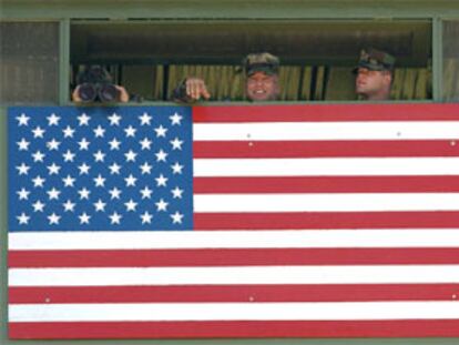 Tres <b></b><i>marines</i> vigilan la frontera entre Cuba y la base de Guantánamo desde un puesto de observación.