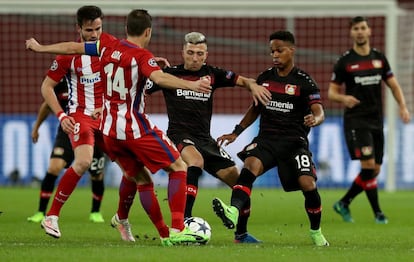 Kevin Kampl (C) y Wendell del Leverkusen luchan por el balón con Gabi del Atlético.