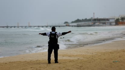 Un policía municipal vigila la playa antes de la llegada del huracán Beryl, en Playa del Carmen, Quintana Roo.