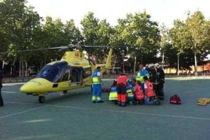 Los sanitarios preparan el traslado en helicóptero de un trabajador herido en un taller de San Fernando de Henares.
