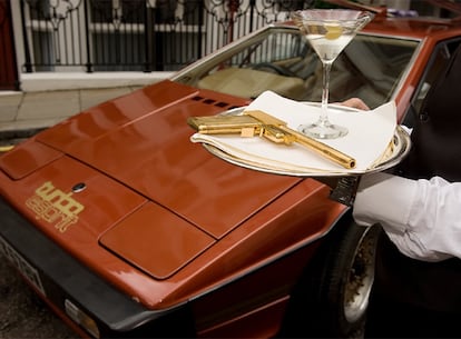 Un trabajador del hotel St. James de Londres muestra la pistola de oro de James Bond junto al coche Lotus Esprit .