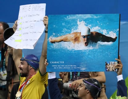 Aficionados aplauden y animan al nadador estadounidense Michael Phelps.