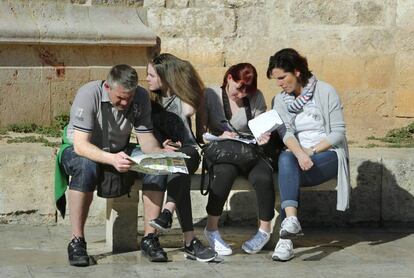 Un grupo de turistas estudia los planos de Valencia.