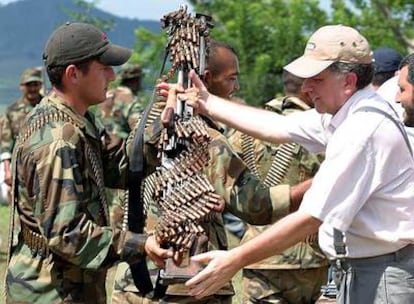 Un paramilitar entrega su arma y munición al negociador gubernamental Luis Carlos Restrepo en la provincia del Valle en 2004.