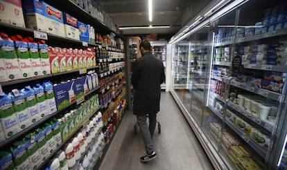 Un consumidor en la línea de productos lácteos de un supermercado en Madrid.