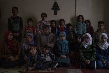 Tahar Ali y Samira Abdala posan para una fotografía junto a sus hijos y otros familiares en su salón. “Los primeros dos años yo tenía un empleo y todo iba bien. Luego enfermé, perdí mi puesto y ahora cada día es peor. Tenemos muchas necesidades, no puedo garantizar sus derechos básicos. Simplemente, el pan es algo inalcanzable para nosotros”, asegura Ali.