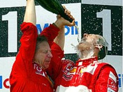 Michael Schumacher celebra junto al director de su equipo, Jean Todt, su victoria.