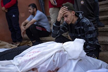 Un hombre llora junto a los cadáveres de sus familiares muertos durante un bombardeo israelí, en la morgue del hospital de Jan Yunis, este sábado.