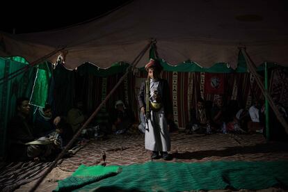Alí Mabjud, de 12 años e hijo de un jeque tribal carga con su escopeta durante una cena en el desierto yemení de Shabwa.