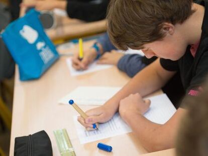 Ni&ntilde;os estudiando.