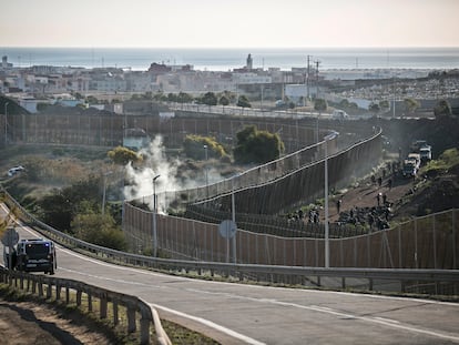 Las fuerzas de seguridad vigilan el perímetro fronterizo de Melilla, este jueves, mientras cientos de inmigrantes aguardan en el lado marroquí.
