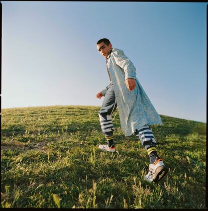 Omar Ayuso viste camisa y abrigo Palomo, pantalón y zapatillas Adidas y calcetines Carhartt WIP. 