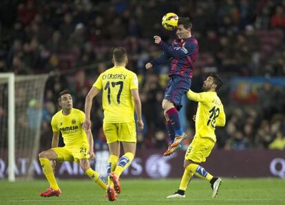 Messi salta a por un bal&oacute;n en el Camp Nou, rodeado de tres jugadores del Villarreal. 