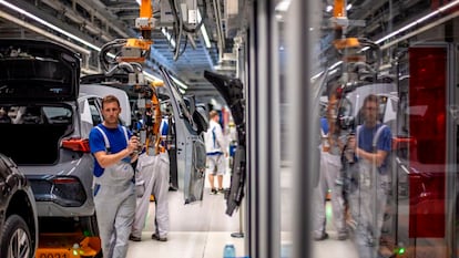 Varios empleados en la línea de montaje de la fábrica de coches eléctricos de Volkswagen en Zwickau (Alemania)