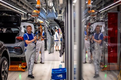 Varios empleados en la línea de montaje de la fábrica de coches eléctricos de Volkswagen en Zwickau (Alemania)