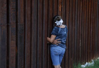 Una mujer es abrazada por su marido, inmigrante ilegal en EE UU, en la frontera entre Nogales, Arizona, y la localidad de Nogales, en Sonora, México. Un juzgado de EE UU ha suspendido los artículos más polémicos de la ley de Arizona, que convierte en delito ser inmigrante ilegal.