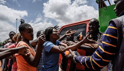 Una mujer recibe alimentos el 2 de abril de 2020, durante una distribución de un grupo de voluntarios kenianos llamados Team Pangaj. Entregan harina, alubias, leche y zumo a unas 900 personas de Kibera, uno de los suburbios más pobres de Nairobi, capital de Kenia.