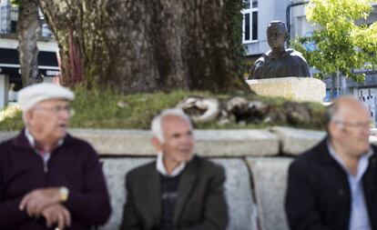 Tres vecinos de Vilalba, ante la réplica de la escultura de Fraga, sentados a los pies de uno de los árboles centenarios de la Alameda de Basanta Olano.