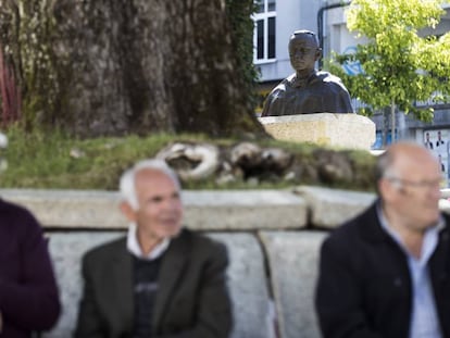 Tres vecinos de Vilalba, ante la réplica de la escultura de Fraga, sentados a los pies de uno de los árboles centenarios de la Alameda de Basanta Olano.