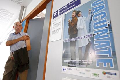 Un hombre sale de una consulta en Vitoria tras administrársele la vacuna de la gripe.