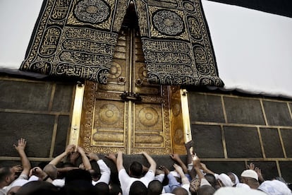 Peregrinos musulmanes tocan la puerta dorada de la Kaaba,el santuario más sagrado del Islam, para recibir su bendición al tocarlo, en la Gran Mezquita de la ciudad sagrada de La Meca (Arabia Saudí).