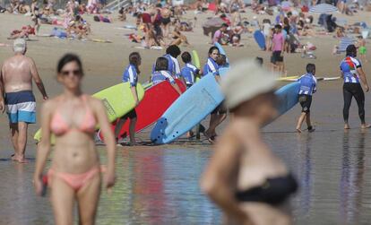 Ba&ntilde;istas y surfistas en la playa de La Zurriola, en San Sebasti&aacute;n.