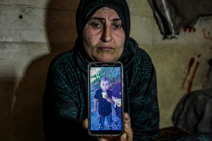 Ferial Al-Najjar, madre del niño palestino Naeem Al-Najjar que murió por desnutrición, muestra una foto de su hijo.