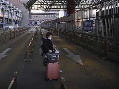 Mulher em um estacionamento de táxi vazio uma estação de trem na região oeste de Pequim.