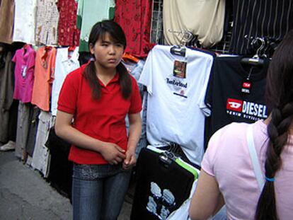 Una vendedora china en un puesto de ropa falsificada en un mercadillo de Pekín.