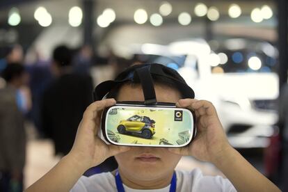 Un joven visitante mira una presentación de realidad virtual en la exposición automotriz internacional de Beijing.