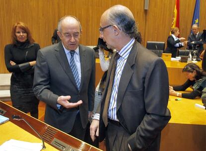 Miguel Ángel Fernández Ordóñez (izquierda) conversa con el portavoz de Economía del PP en el Congreso, Cristóbal Montoro.