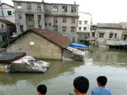 Un grupo de personas observan las calles inundadas de Yueyang, localidad cercana al lago Dongting.