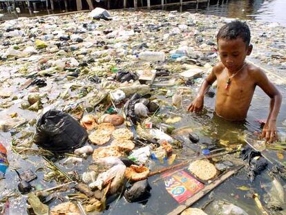 Un niño indonesio juega en una balsa de agua llena de basura en Muara Baru, al norte de Yakarta.