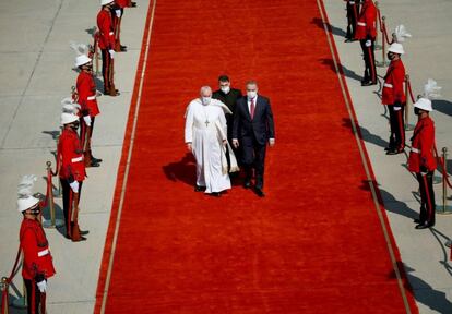 El primer ministro iraquí, Mustafa Al-Kadhimi (a la derecha), acompaña a Francisco tras aterrizar en el aeropuerto de Bagdad. El Papa se ha encontrado un país confinado por la pandemia y sometido a extremas medidas de seguridad.