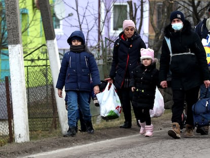 Una familia ucrania se dirige al paso fronterizo de Shehyni, en Ucrania, hacia Polonia.