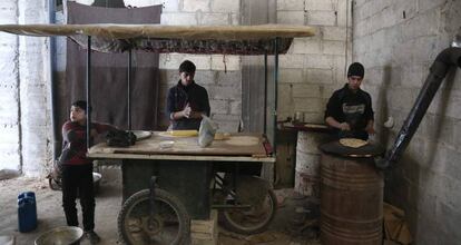 Un grupo de ni&ntilde;os sirios prepara pan, este martes en Hamouria (Guta Oriental).