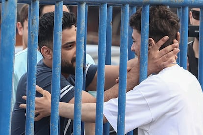 Syrian survivor Fedi, 18, right, one of 104 people who were rescued from the Aegean Sea after their fishing boat crammed with migrants sank, reacts as he reunites with his brother