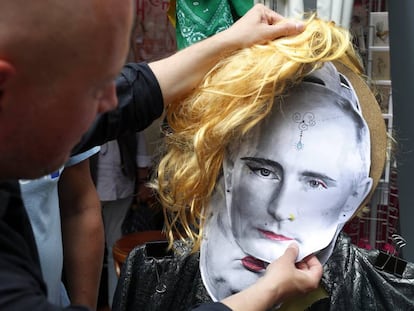 Un hombre coloca una careta de Putin maquillado durante el Festival de Gays y Lesbianas en Berl&iacute;n.