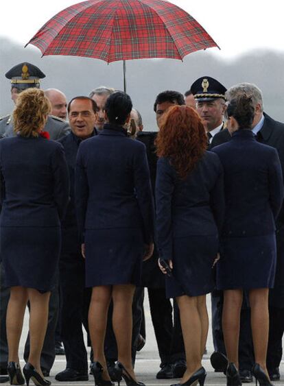 Berlusconi es recibido en Cerdeña por varias azafatas a su llegada al aeropuerto para esperar al presidente ruso, Vladímir Putin, que pasó dos días en su residencia de verano.