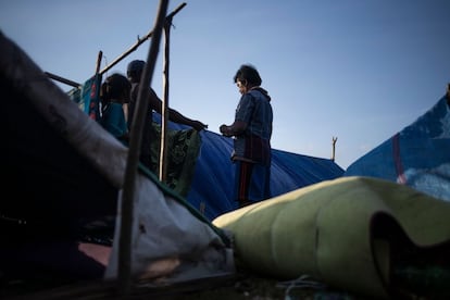 La gente construye una carpa en un refugio temporal en el pueblo de Menangga Baris.