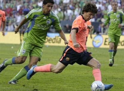 El jugador del Barcelona Messi, a punto de lanzar ante la presencia de Leonardo González, de los Seattle Sunders.