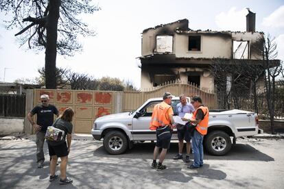 Miembros del Ministerio de Infraestructuras revisan los daños ocasionados en cada una de las viviendas tras el incendio en el muinicipio de Rafina, el 26 de julio de 2018.