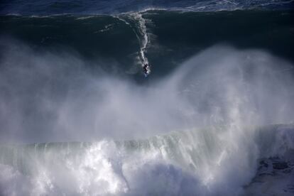 Un surfista cabalga una gran ola durante una sesión de tow-in surfing.