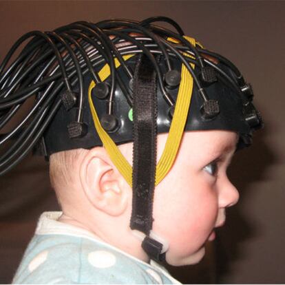 Un bebé con un casco con sensores ópticos para medir su actividad cerebral.