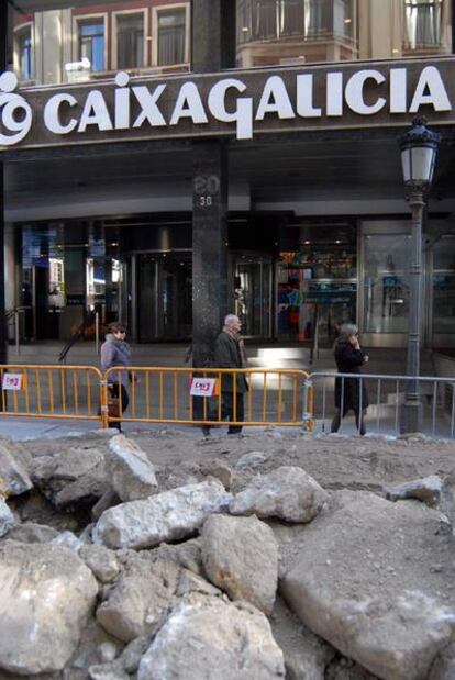 Sede centra de la antigua Caixa Galicia, en A Coruña, con la calle en obras.