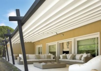 Pérgola moderna con toldo y pilares gruesos decorativos de Greendesign.
