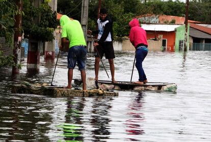 Un grupo de jóvenes se desplaza por una calle inundada del barrio Tacumbú en Asunción, Paraguay.